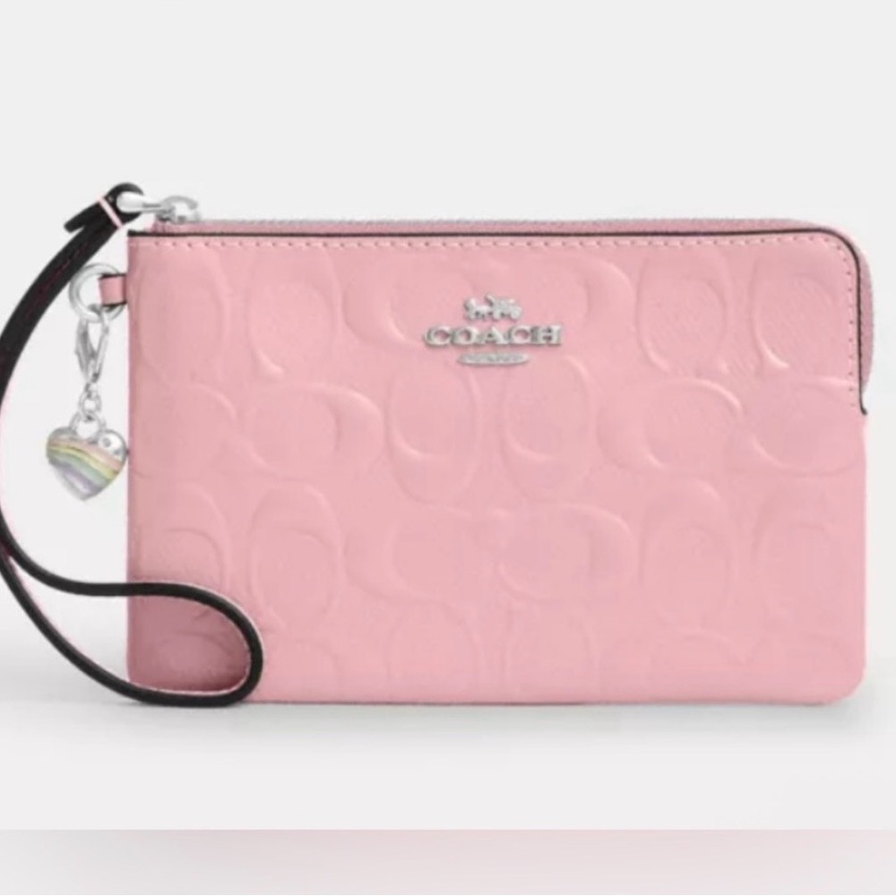 Coach Corner Zip Wristlet in Signature Leather with a heart charm in a pink hue